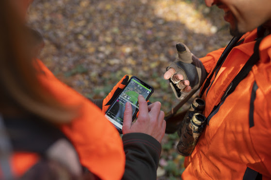 couple looking at DNR hunt app on smartphone