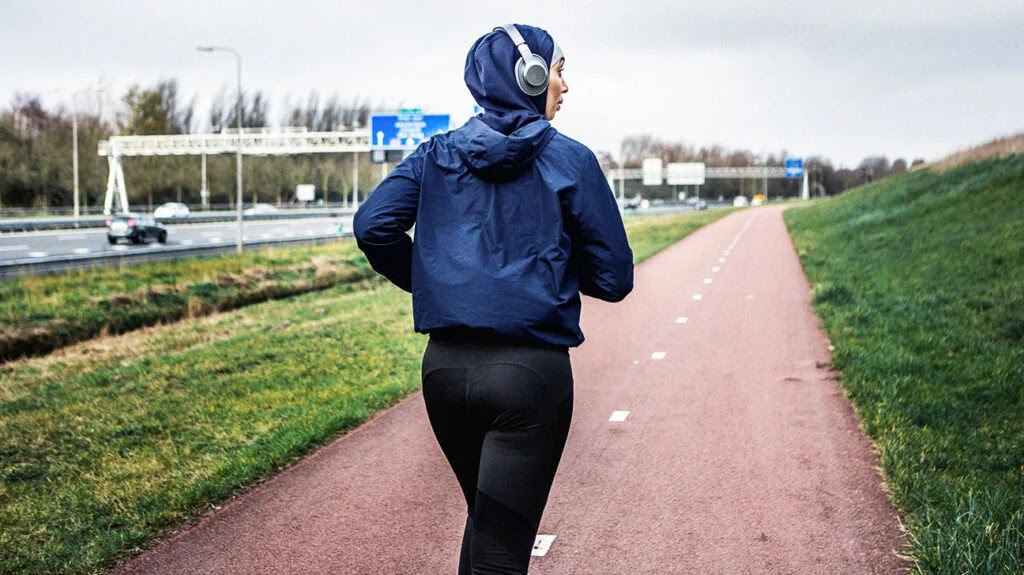 Female runner on a run along the side of a motorway