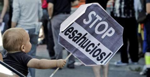 Niño portando una pancarta de 'Stop Desahucios'