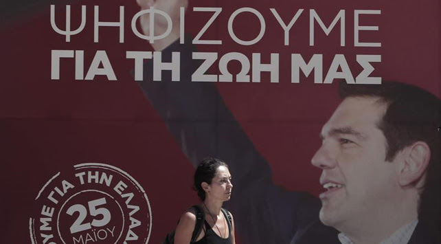 Una mujer pasa por delante de un cartel elecotral de SYRIZA en el centro de Atenas, Grecia.