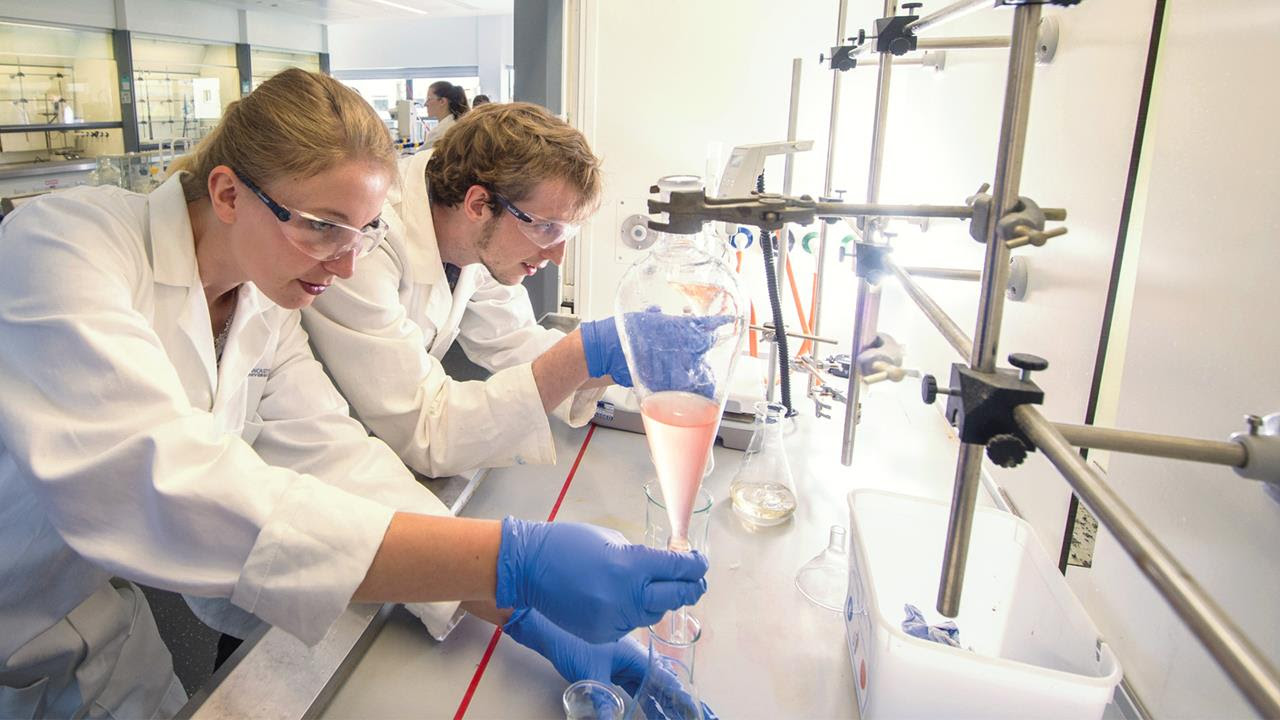Image of 2 students working in a chemistry lab