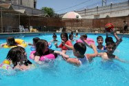 Arab Children swimming in a pool in Hebron, filled with water supplied by Mekorot, Israel.