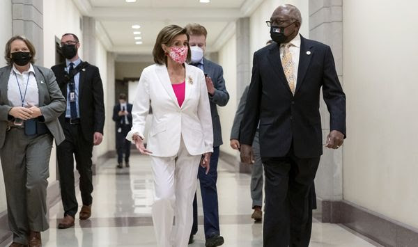 Speaker of the House Nancy Pelosi, D-Calif., walks with House Majority Whip James Clyburn, D-S.C., right, to meet with reporters after the House approved the Democrats&#39; social and environment bill, giving a victory to President Joe Biden, at the Capitol in Washington, Friday, Nov. 19, 2021. (AP Photo/J. Scott Applewhite)