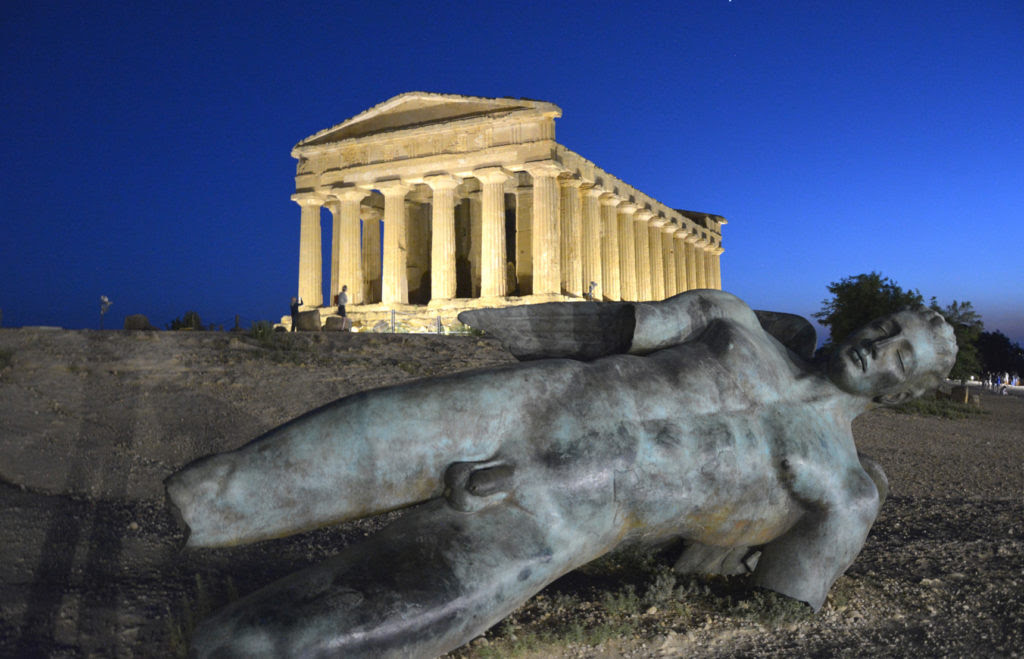 Pasqua in Sicilia - Il partenone di Agrigento illuminato nella notte e in primo piano una parte di statua appoggiata per terra