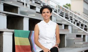 Camila García, vicepresidenta del síndicato FIFPro, sentada en una gradería con la bandera del colectivo LGBT+
