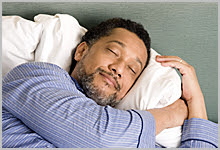 Man peacefully sleeping with a smile on his face.