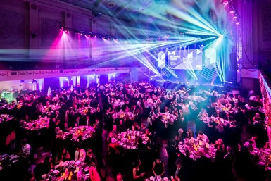 A large hall filled with tables and people.