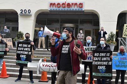 Masked man with bullhorn leads demonstration for vaccine equity infront of moderna lab Masked man with bullhorn leads demonstration for vaccine equity infront of moderna lab