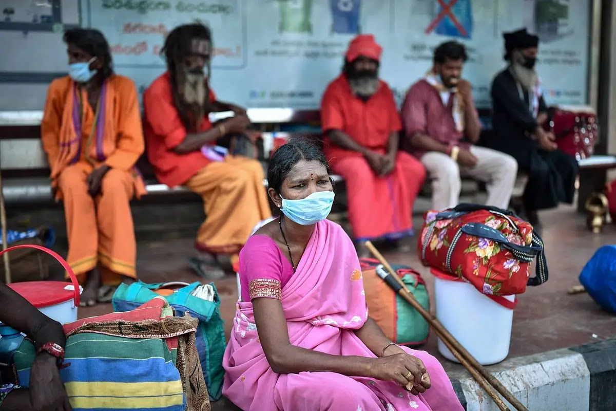 एक महिला विजयवाड़ा में क्वॉरंटीन से निकलने के बाद विजयनगरम में अपने मूल स्थान पर लौटने के लिए बस स्टॉप पर इंतजार करती हुई.