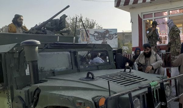 Taliban fighters stand guard in Kunduz city, northern Afghanistan, Monday, Aug. 9, 2021. The militants have ramped up their push across much of Afghanistan in recent weeks, turning their guns on provincial capitals after taking district after district and large swaths of land in the mostly rural countryside. (AP Photo/Abdullah Sahil)