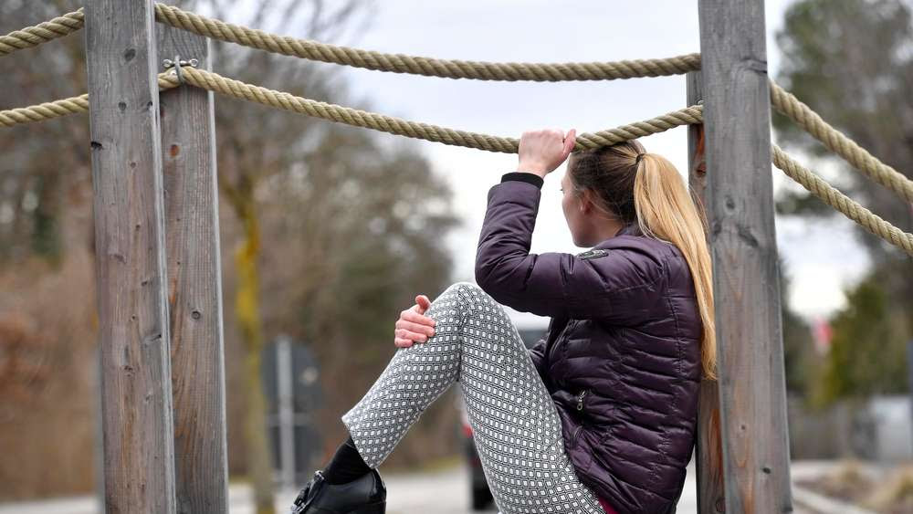 Vergwaltigungsopfer Daniela R. sitzt auf
                      einer Holzbrücke in München.