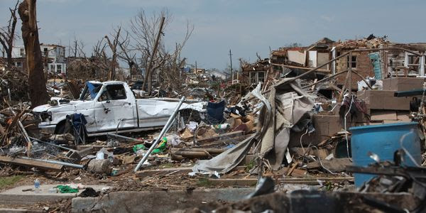 Ravaged homes stand in shambles after a tornado passes through.