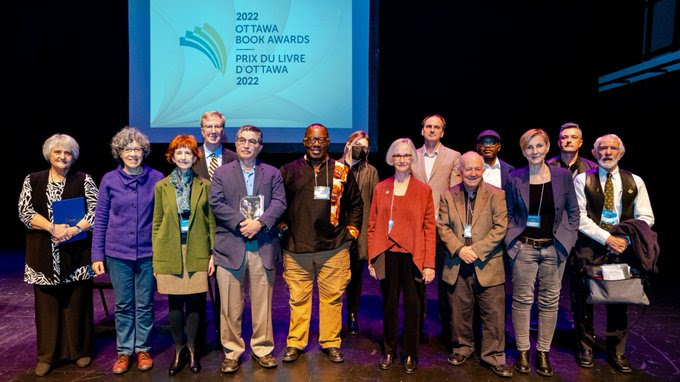 Group shot of the winners and finalist for the 2022 Book Awards. Mayor Watson is seen in the background. 
