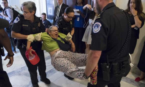 Police arrest a protestor against the Senate Republican’s draft healthcare bill outside the office of Mitch McConnell. 