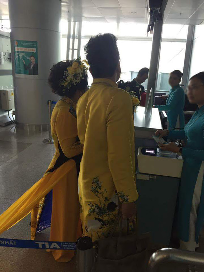 Vợ MC Thanh Bạch diện áo dài như đuôi công lên máy bay khiến nhiều hành khách choáng - Ảnh 1.