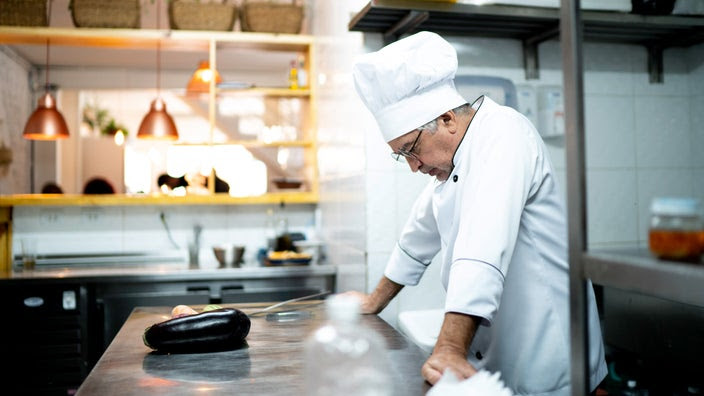 A depressed chef in a kitchen.