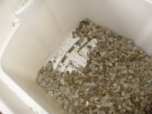 Bin showing drainage holes in one end, with 5cm gravel then spread on base.