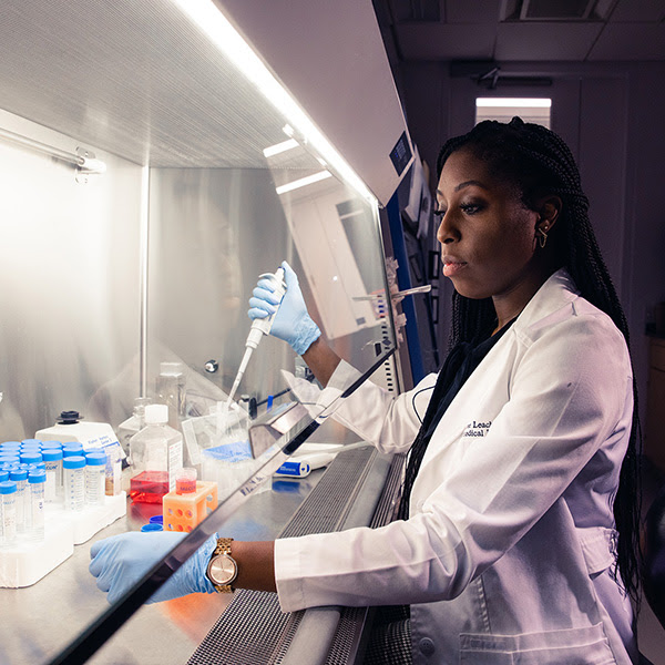 Desireé Leach uses a pipettor to transfer kidney cells to a fresh dish.