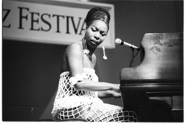 Nina Simone plays the piano and sings in concert. Nina Simone plays the piano and sings in concert.