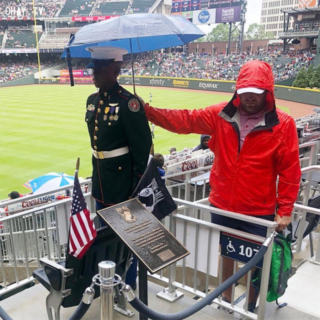 Fan bóng chày cầm ô che cho sĩ quan dự bị trong Ngày Tưởng niệm Liệt sĩ ở Mỹ.,Hoa Kỳ,nước mỹ,lòng nhân ái