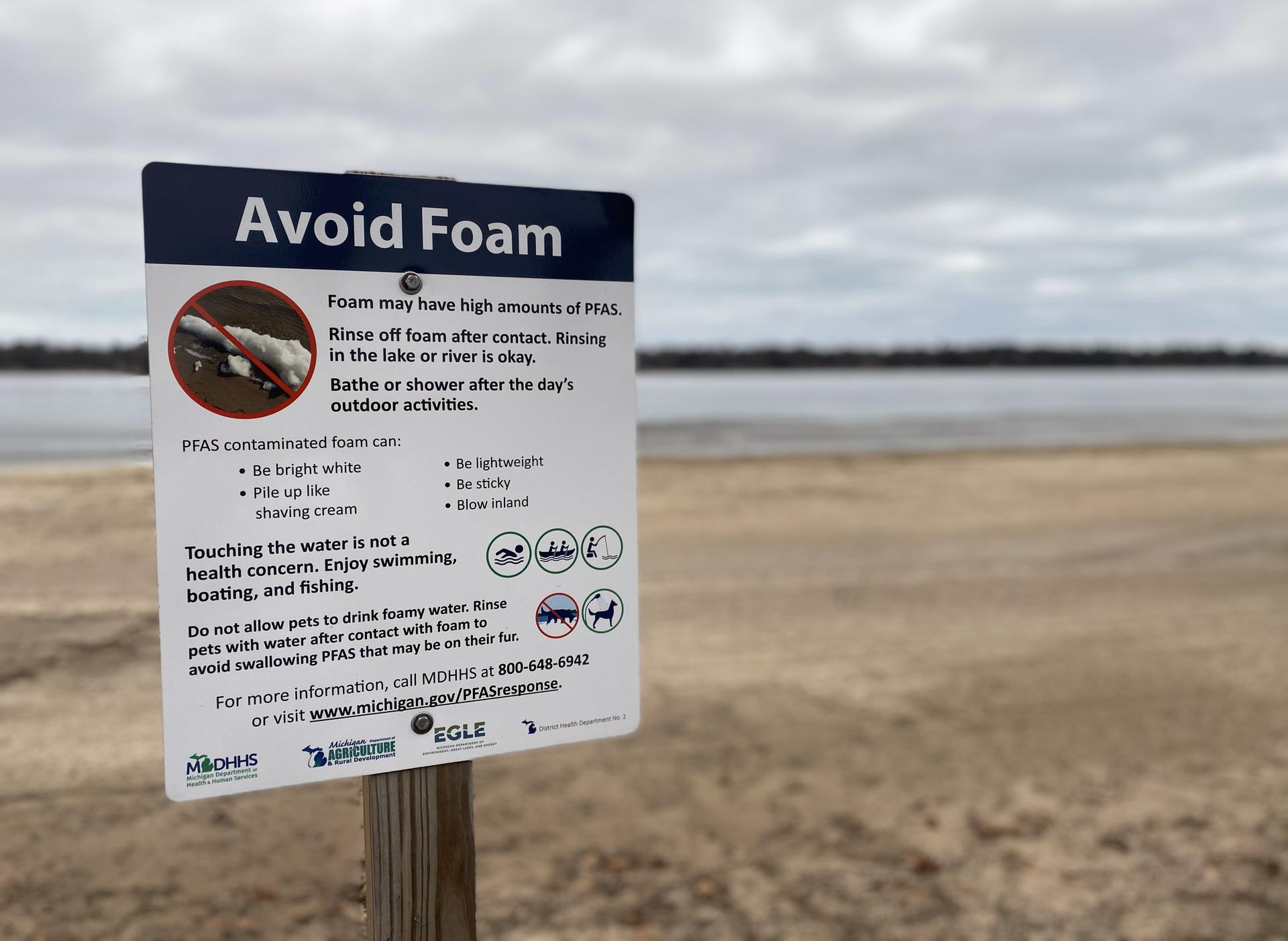 A warning sign posted on a lakeshore beach that says ''Avoid Foam''