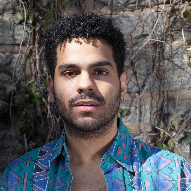 Marketing Fellow Gerard Minaya is a genderqueer, Afro Latino person in a 5'8" attuned body with kinky-curly hair.
