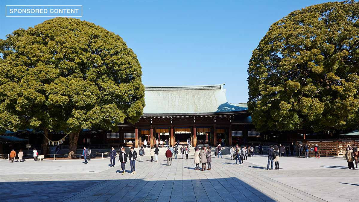 Le sanctuaire Meiji Jingu Shibuya, Tokyo, avec une petite foule de personnes debout devant lui.