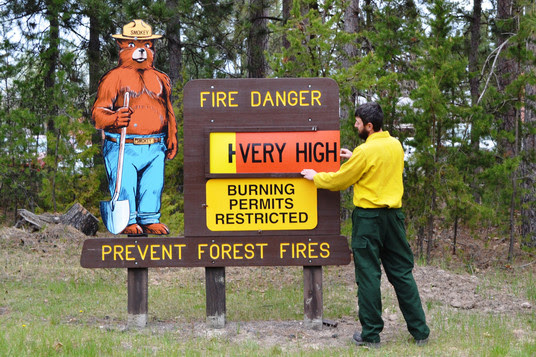 DNR forester adding a High Fire danger sign