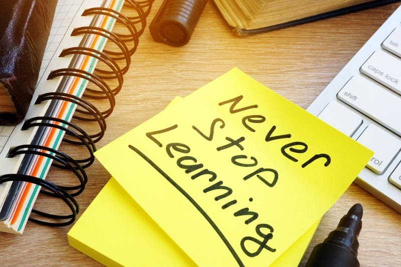 post it note with never stop learning written on it