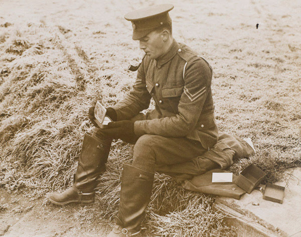 Photo of a soldier opening his Princess Mary's Gift tin in 1914