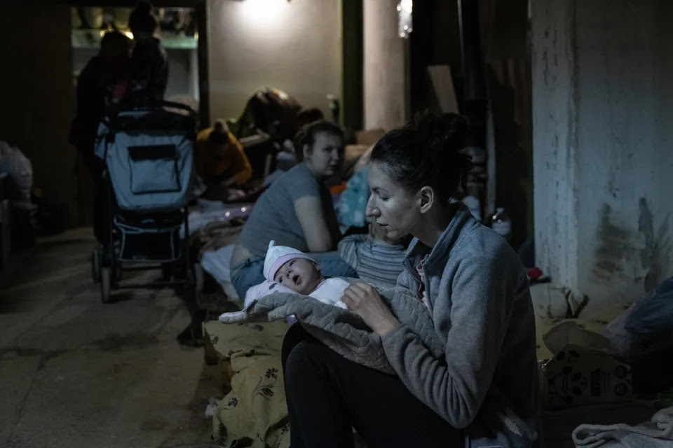 A mother tends to her baby in a bomb shelter.