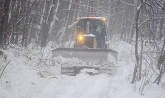 A bulldozer moves along a snowmobile trail in Marquette County.