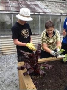 Extension Master Gardener instructs student in vegetable gardening.