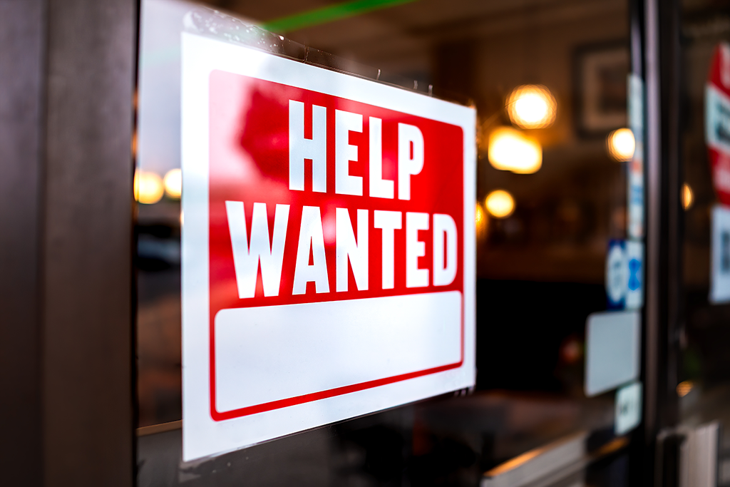 A help wanted sign in a window