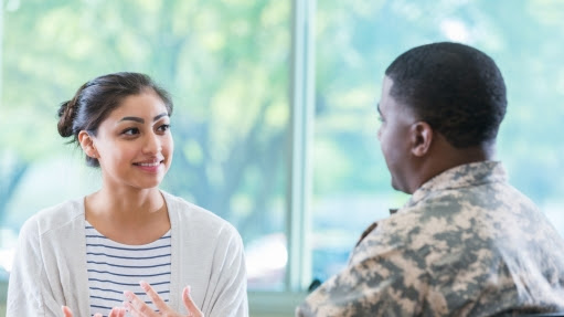 A military officer talks with a young woman in recruitment office