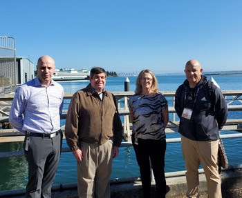 Photo of four people standing in front of a few ferries