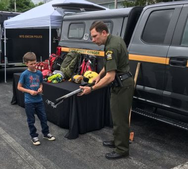 Ranger showing a child a tool 