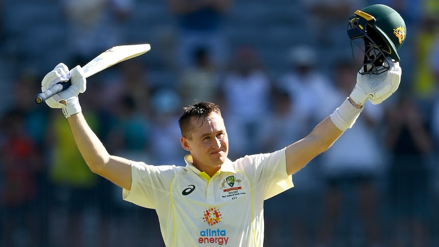 Australia batter Marnus Labuschagne raises his bat and helmet to celebrate a Test century against West Indies.