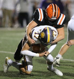 Hunter Geissinger, 17, of Jackson is sacked by Drew Logan, rear, of Hoover during their game at Hoover on Friday, Oct. 22, 2021.