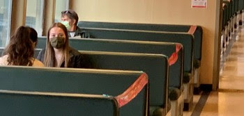 Photo of riders sitting in booths aboard ferry wearing masks