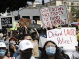 Demonstrators holds signs during a protest to demand the defunding of the Los Angeles school district police outside of the school board headquarters Tuesday, June 23, 2020, in Los Angeles. (AP Photo/Marcio Jose Sanchez) ** FILE **