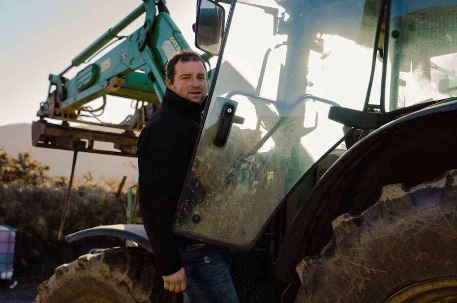 A person standing next to a tractor Description automatically generated with medium confidence
