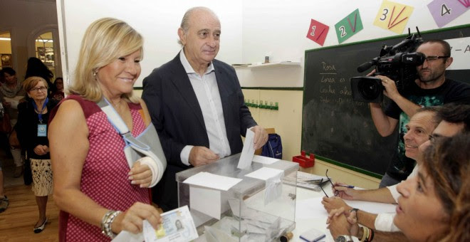 El ministro del Interior, Jorge Fernández Díaz, junto a su esposa Asunción Carcoba, ejerce su derecho a voto en las elecciones al parlamento autonómico catalán, en la Escola Augusta. EFE/Marta Pérez