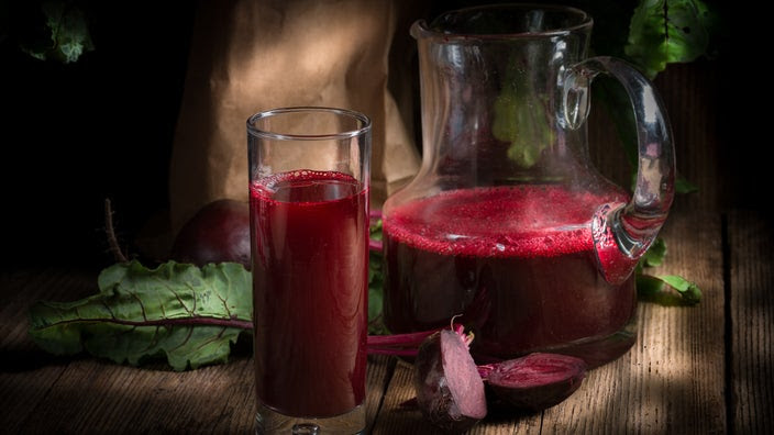 A still-life image shows beet juice and a carafe.