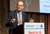 Dr. Roger I. Glass speaks from a podium labeled CUGH 2018, slide projected in the background