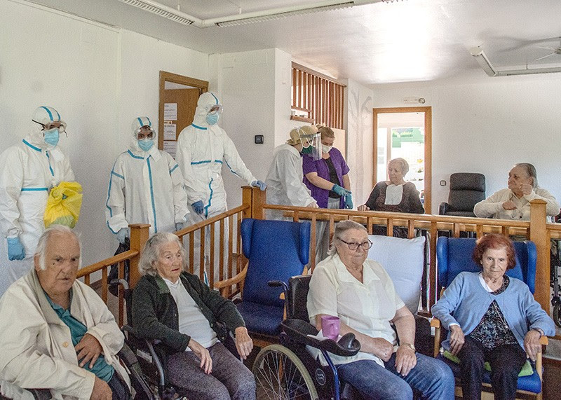 Health care nurses in PPE with the elderly residents at a retirement home in Spain.