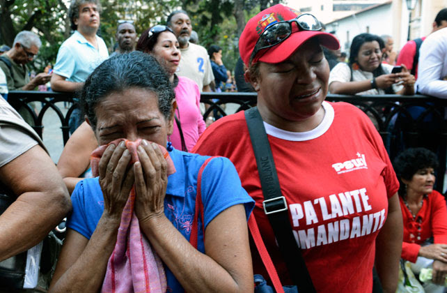 Dos venezolanas lloran en una marcha en homenaje al recuerdo de Hugo Chávez.