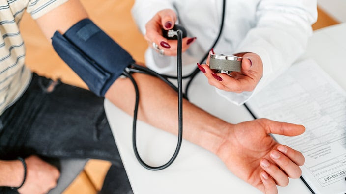 A doctor is measuring a person’s blood pressure.