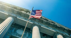 image of U.S. flag waving in front of a government building