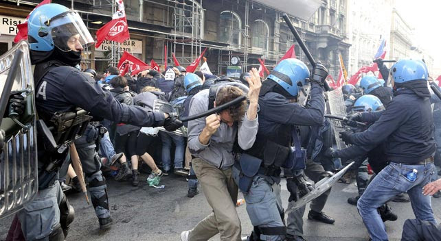 Un antidisturbios golpea a una manifestante durante la protesta contra la austeridad en Roma.